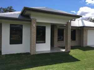 Brick and rendered home with dark-tinted windows and metal roof