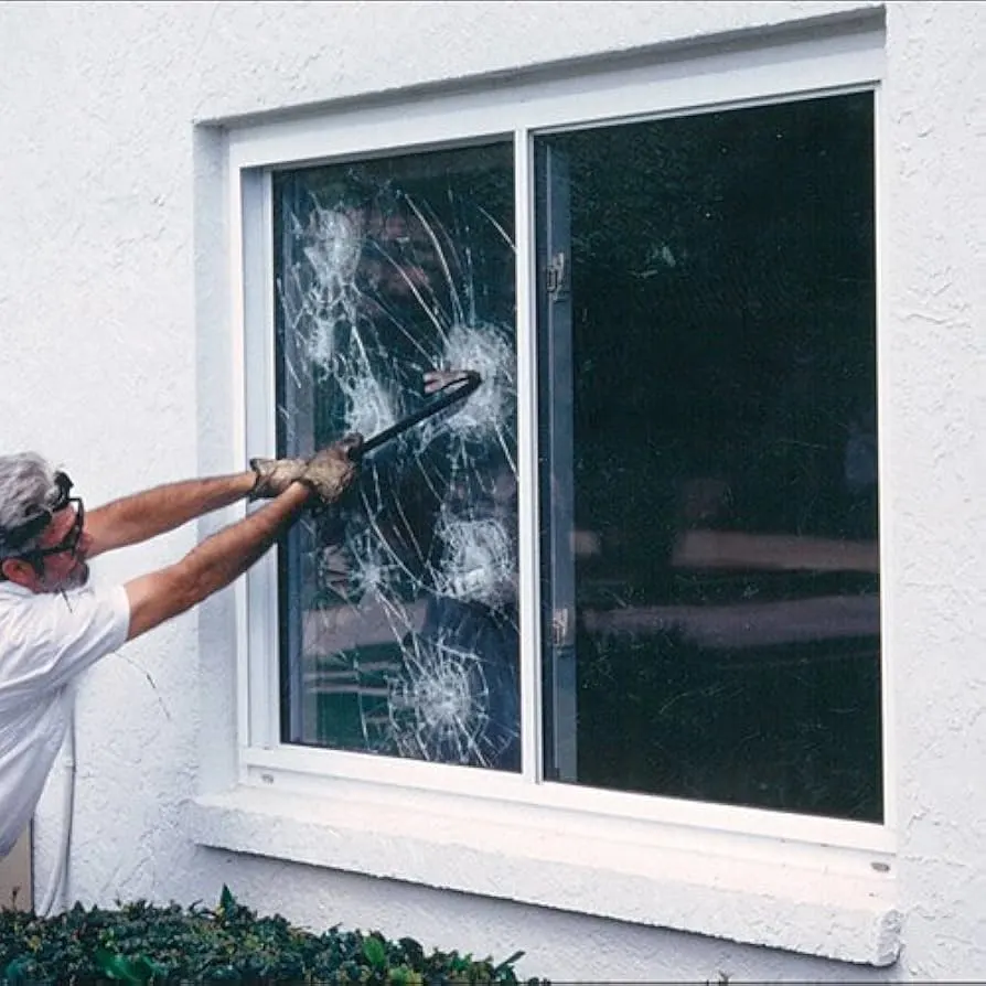 Man hitting window with crowbar to demonstrate strength of security film